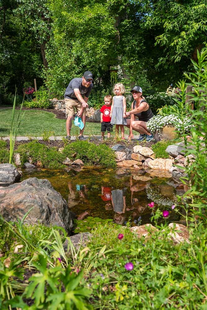 Adult and children pointing at water in a river