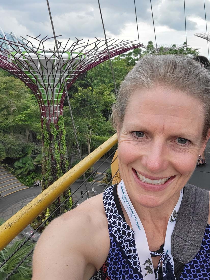 Blond woman smiling at camera with supertree behind her