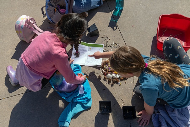 two girls working on a school project outside